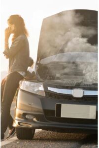 Mechanic checking engine to find cause of white smoke from exhaust when starting car