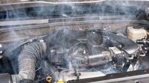 Mechanic checking faulty oxygen sensor causing white smoke from car exhaust