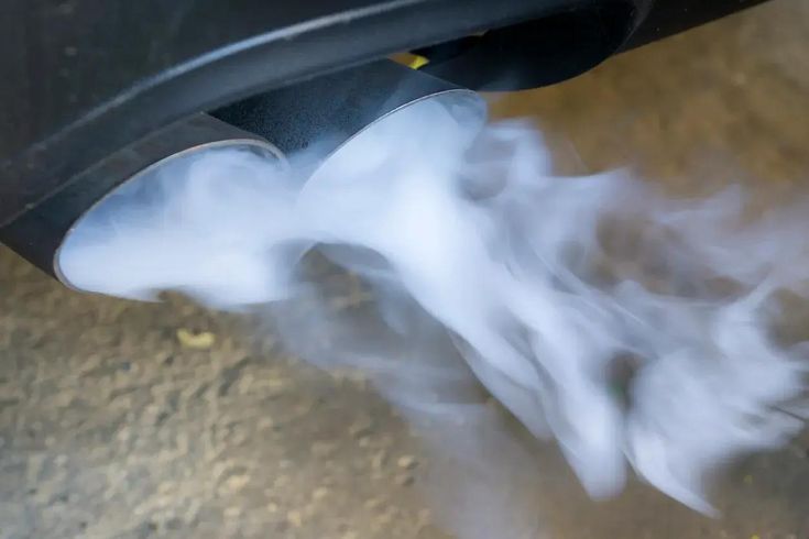 Car releasing white smoke from exhaust when starting car on a cold morning